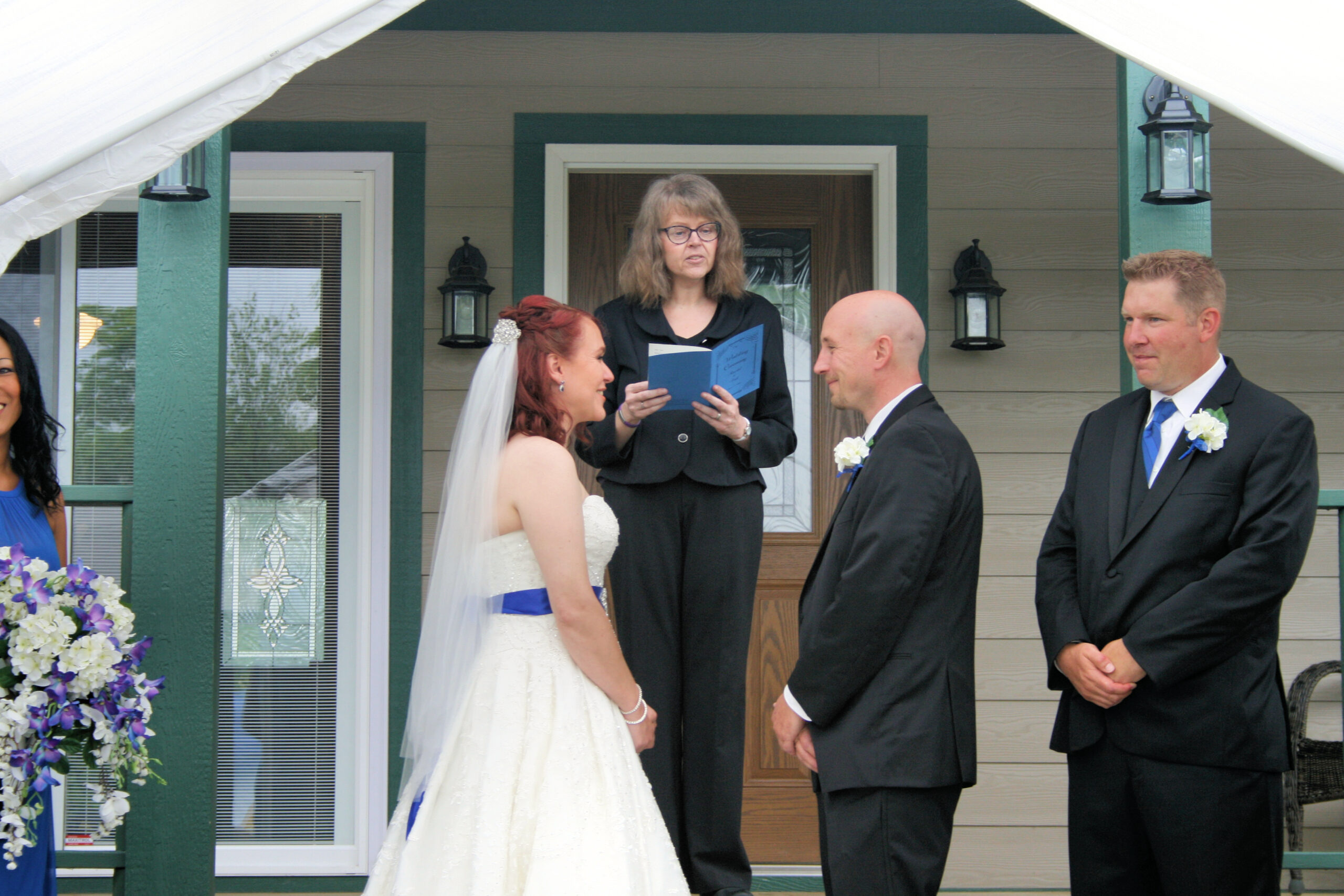 Bride and groom getting married on front porch with officiant