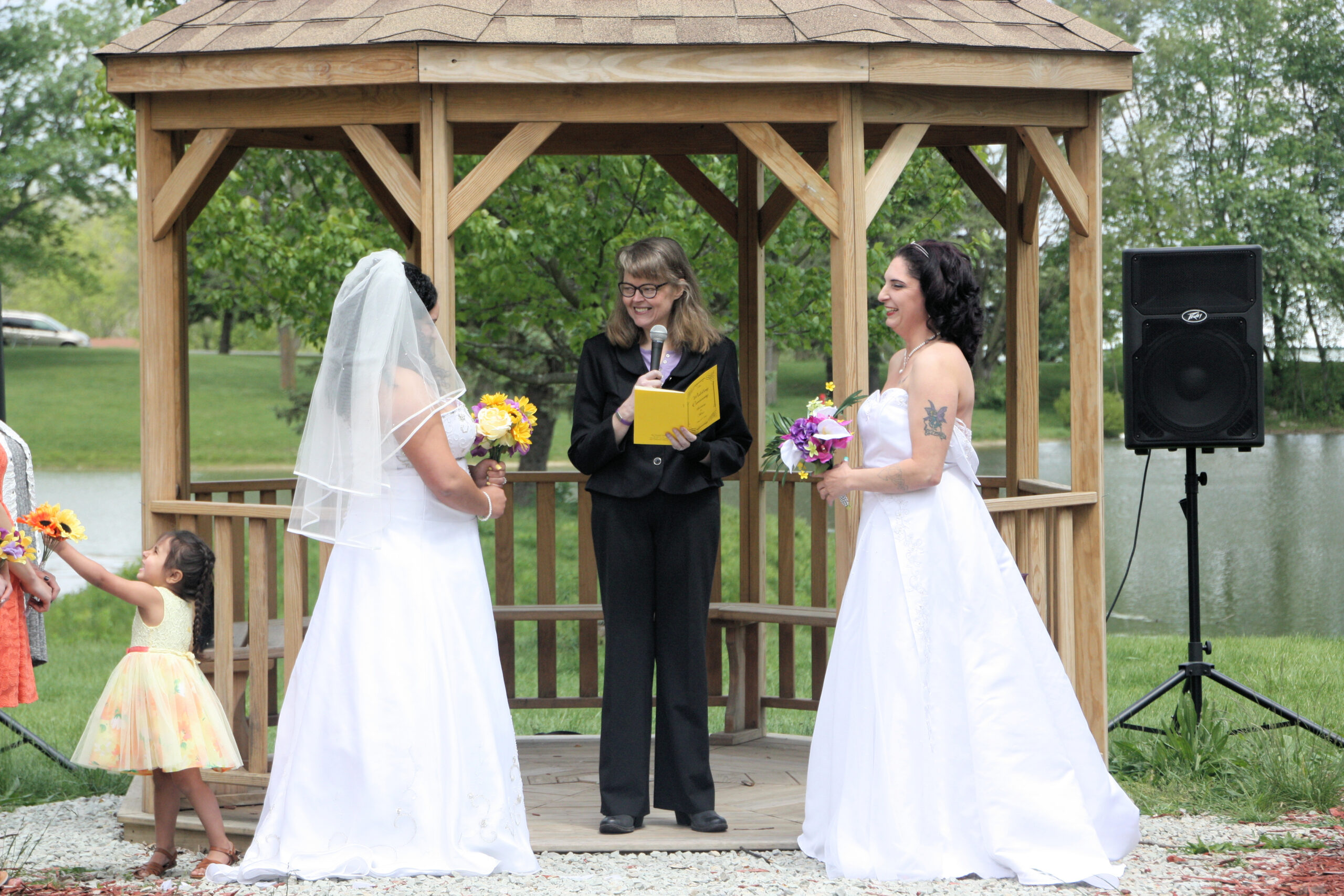 Two brides at alter getting married by officiant