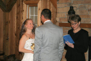 A bride and groom standing before an officiant during a wedding ceremony.