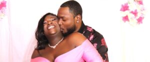 A man kissing a smiling woman on the cheek.