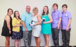 A group of seven adults posed for a photo at a formal event.