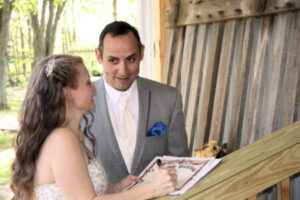A bride and groom signing their marriage certificate.
