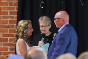 An officiant performs a wedding ceremony for a couple.